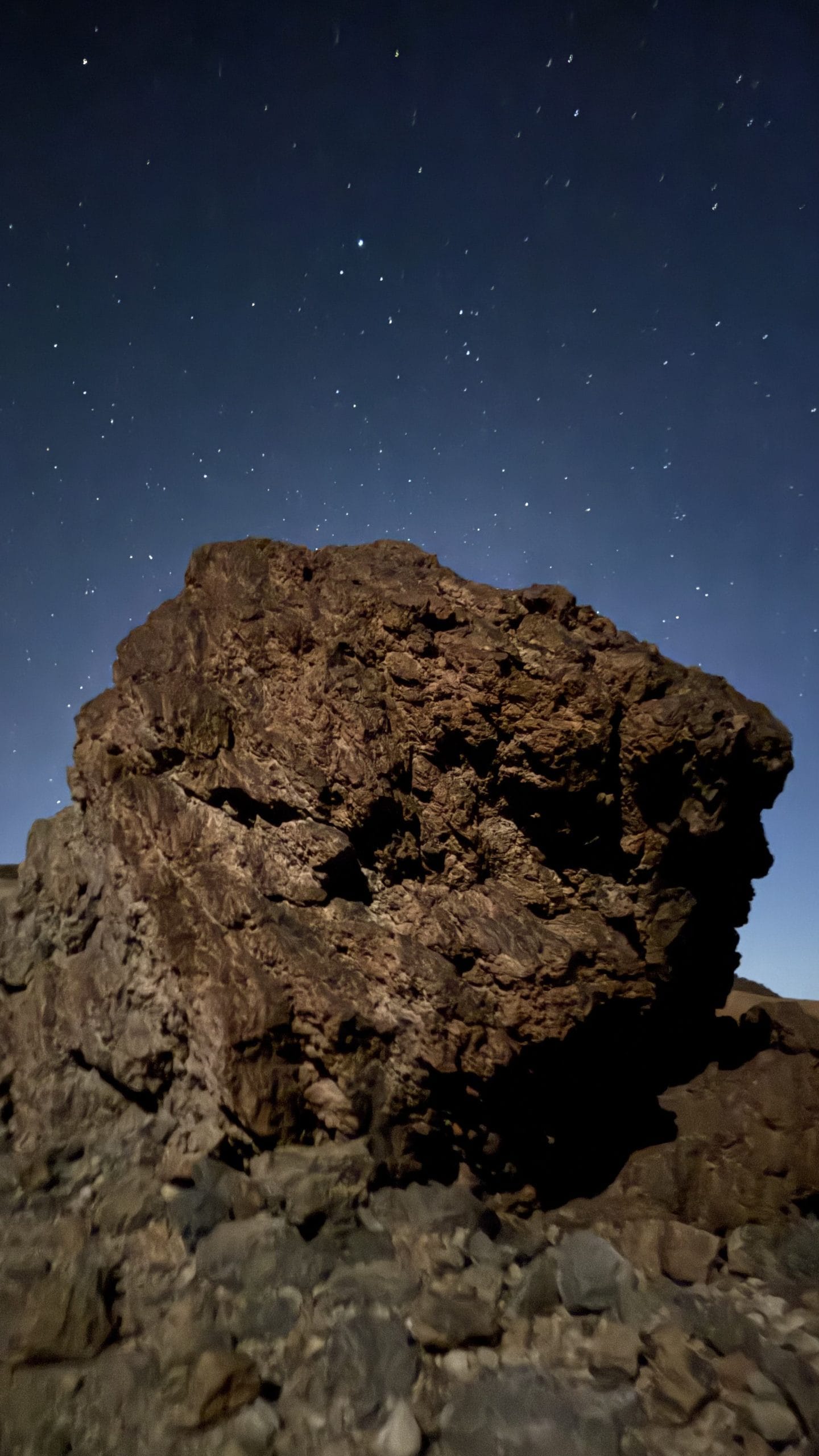Roche volcanique éclairée par la lampe frontale pendant la montée de nuit