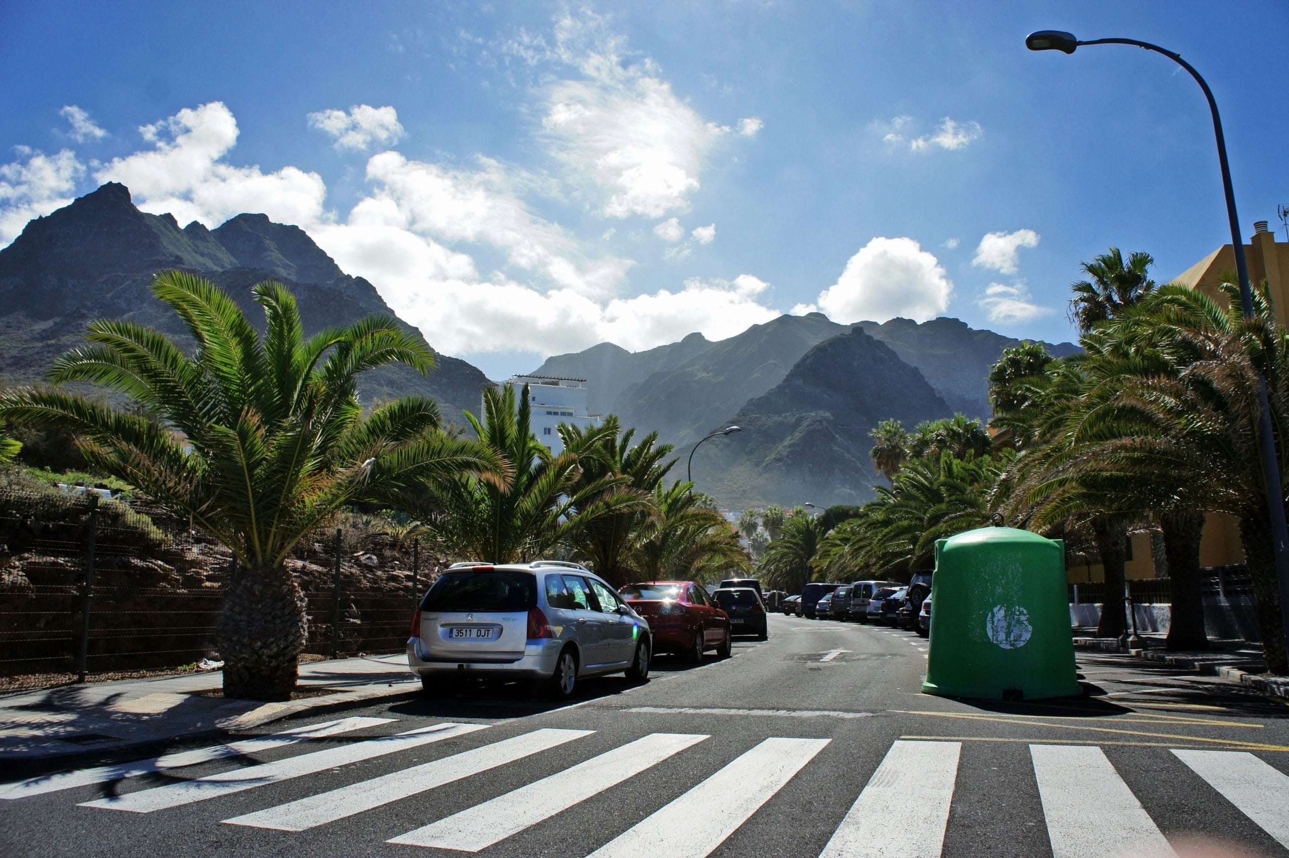 Une route de montagne à Tenerife avec des voitures garées au pied des sommets
