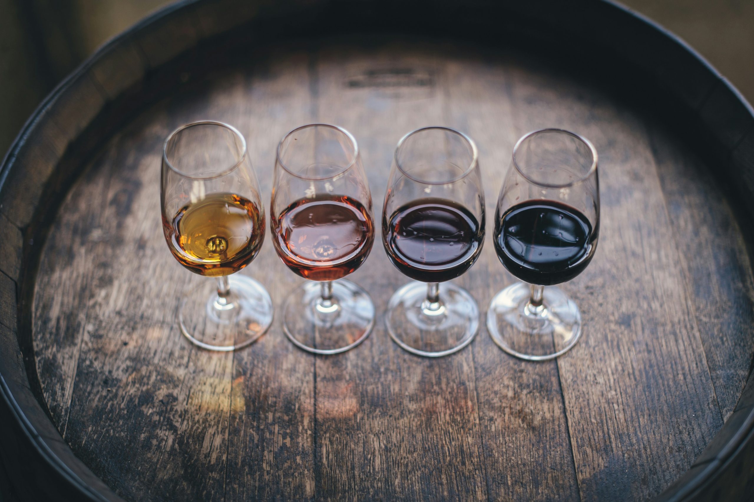 Flight de dégustation de quatre vins de Tenerife aux robes différentes sur un tonneau